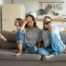 Exhasperated parents on couch watching out-of-control kids