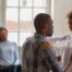 African-American man gently talking with his daughter while smiling mom looks on